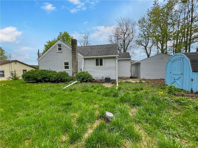 131 W Sullivanville Rd, Veteran, NY 14845 - back of house featuring a shed, cooling unit, a chimney, an outbuilding, and a shingled roof