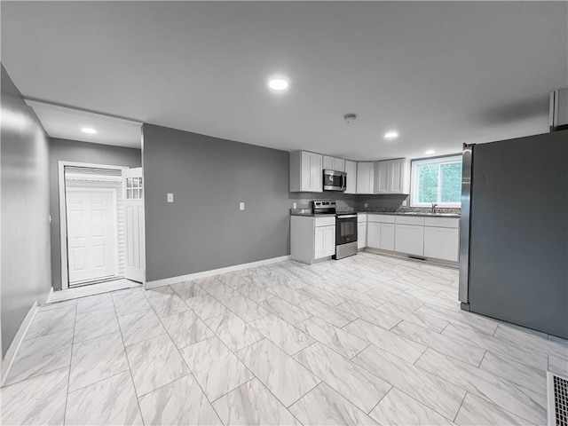 131 W Sullivanville Rd, Veteran, NY 14845 - kitchen with appliances with stainless steel finishes, light marble finish floors, white cabinets, dark countertops, and baseboards