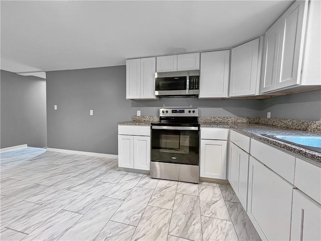 131 W Sullivanville Rd, Veteran, NY 14845 - kitchen featuring appliances with stainless steel finishes, light marble finish flooring, white cabinets, and baseboards