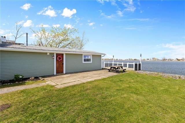 exterior space with a yard, a patio, and a water view