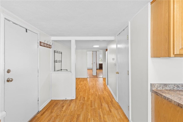 hall featuring light wood finished floors and baseboards