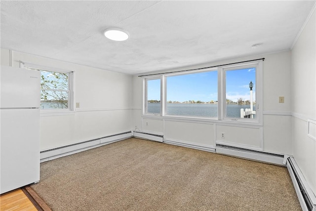 carpeted empty room with a water view, baseboard heating, and a baseboard heating unit