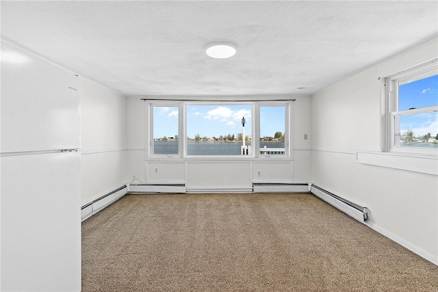 unfurnished room featuring carpet flooring, baseboard heating, and plenty of natural light