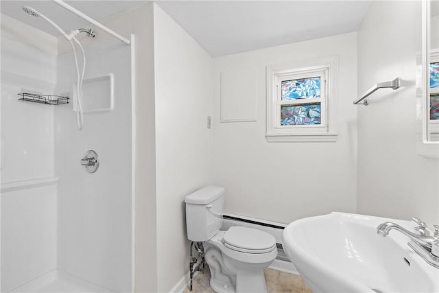 bathroom featuring a shower stall, baseboards, toilet, and a sink