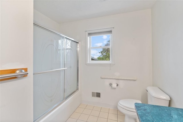 bathroom featuring tile patterned flooring, toilet, visible vents, and enclosed tub / shower combo