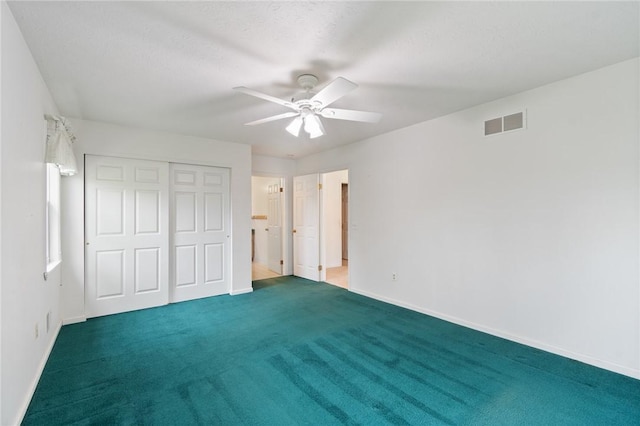 unfurnished bedroom with carpet flooring, a closet, visible vents, and baseboards