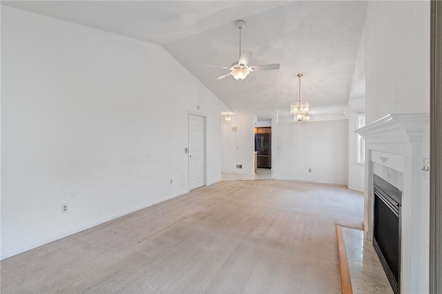 unfurnished living room with ceiling fan with notable chandelier, high vaulted ceiling, a fireplace with flush hearth, baseboards, and light colored carpet