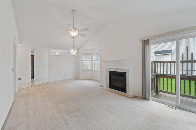 unfurnished living room with a fireplace, carpet, ceiling fan with notable chandelier, and visible vents