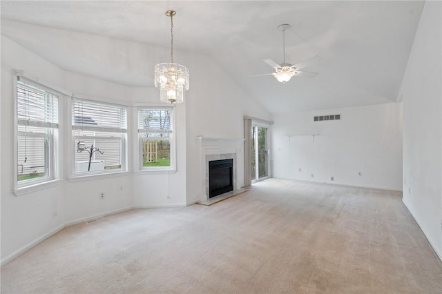 unfurnished living room featuring light carpet, a high end fireplace, visible vents, and ceiling fan with notable chandelier