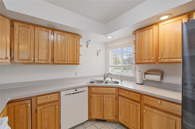 kitchen with freestanding refrigerator, dishwasher, light tile patterned floors, a sink, and light countertops