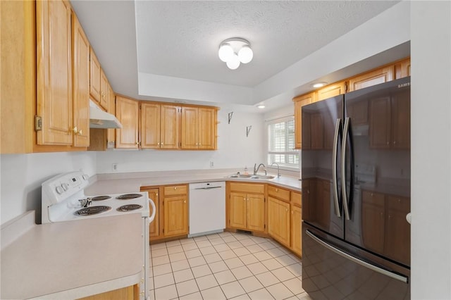 kitchen featuring white appliances, under cabinet range hood, light countertops, and a sink
