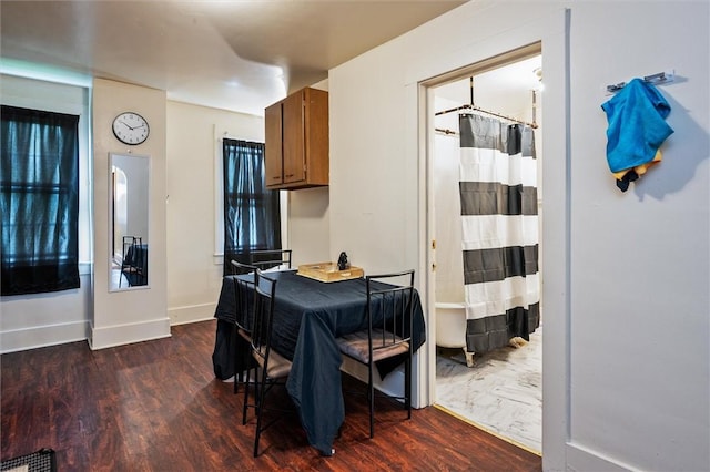 dining room with dark wood finished floors, visible vents, and baseboards