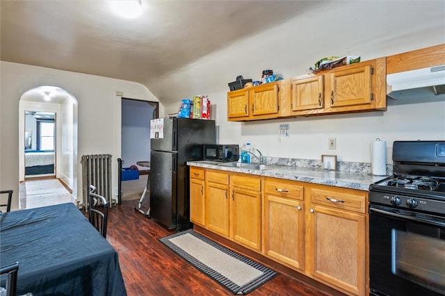 kitchen featuring radiator, a sink, extractor fan, vaulted ceiling, and black appliances