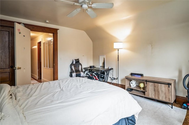 carpeted bedroom featuring vaulted ceiling, baseboards, and ceiling fan