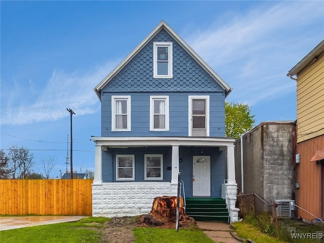 traditional style home with central AC, covered porch, and fence