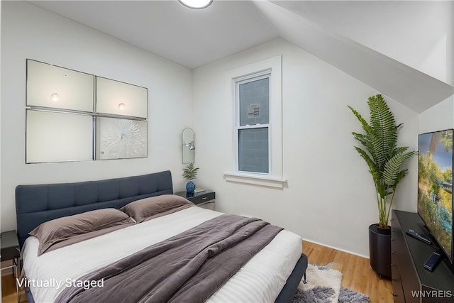 bedroom featuring vaulted ceiling and light wood-style flooring
