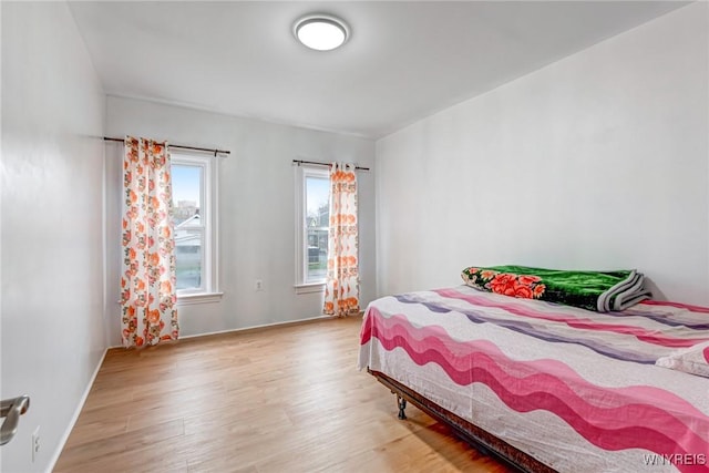 bedroom with baseboards and wood finished floors