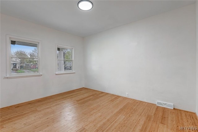 empty room featuring visible vents and wood finished floors