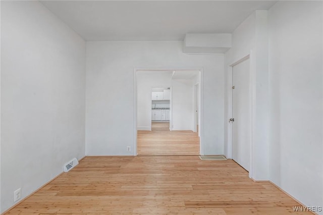 corridor with visible vents and light wood-style flooring