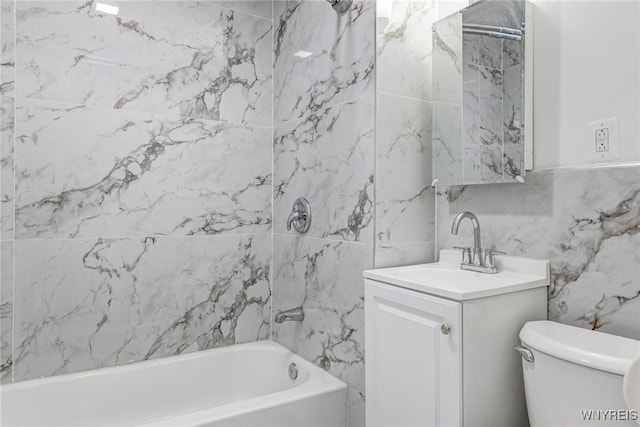 full bathroom with toilet, tile walls, bathing tub / shower combination, and vanity
