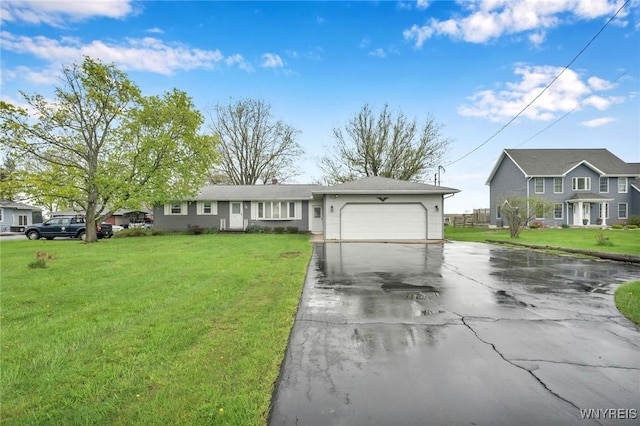 ranch-style home with a front lawn, aphalt driveway, and an attached garage