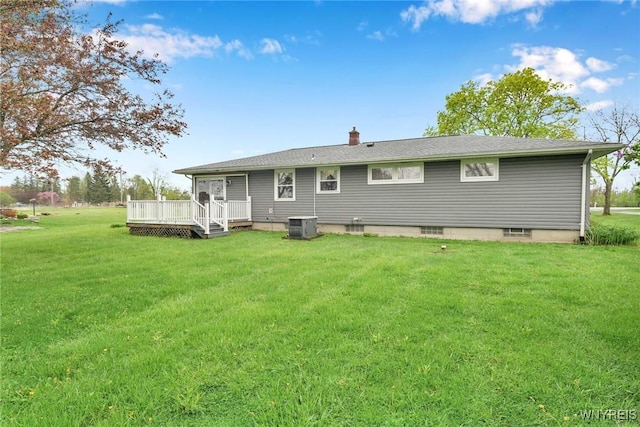 rear view of property with cooling unit, a chimney, a deck, and a lawn