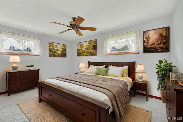 bedroom with light colored carpet, baseboards, and multiple windows