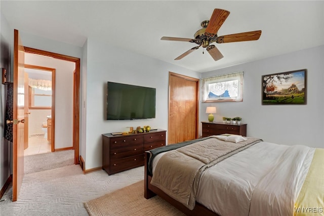 bedroom with light carpet, a closet, baseboards, and a ceiling fan