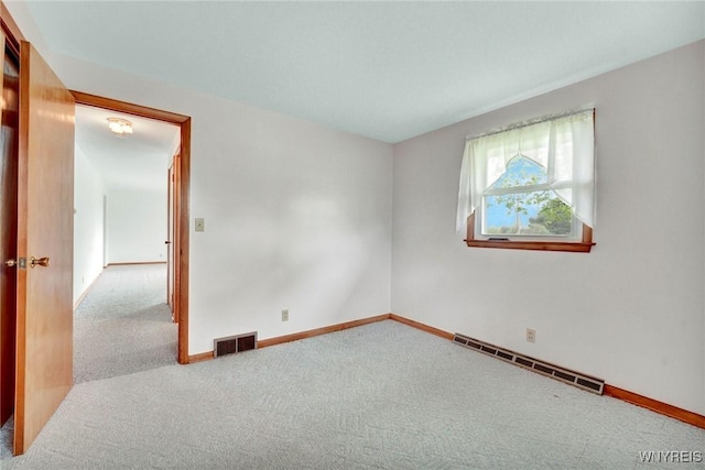 carpeted spare room with visible vents, baseboards, and a baseboard heating unit