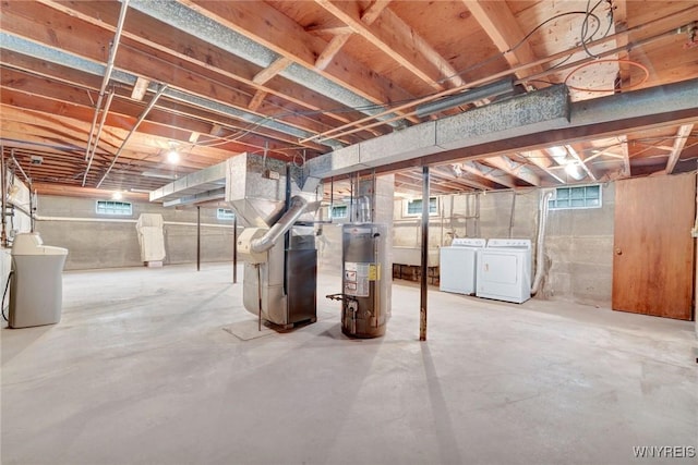 below grade area featuring separate washer and dryer, plenty of natural light, heating unit, and gas water heater