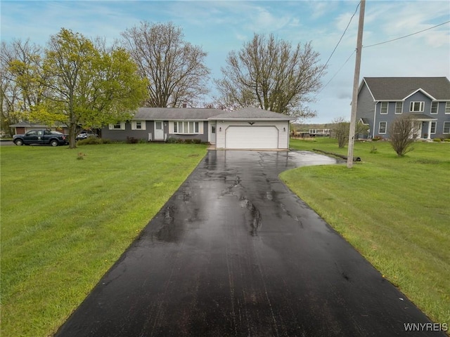 view of front of house with an attached garage, driveway, and a front yard