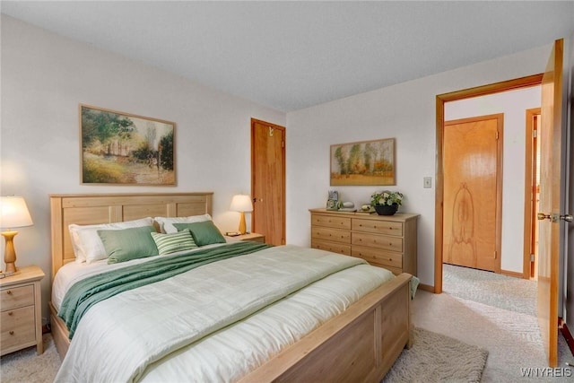 bedroom featuring light colored carpet and baseboards