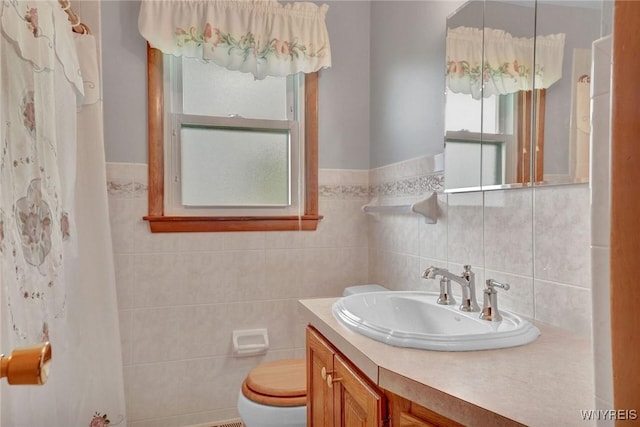 bathroom featuring tile walls, toilet, and vanity
