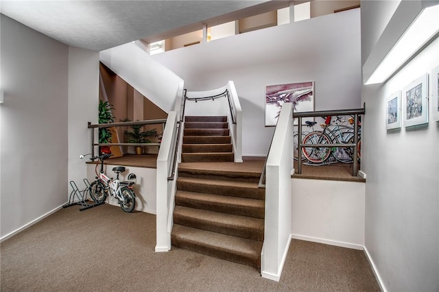 stairway featuring carpet and baseboards