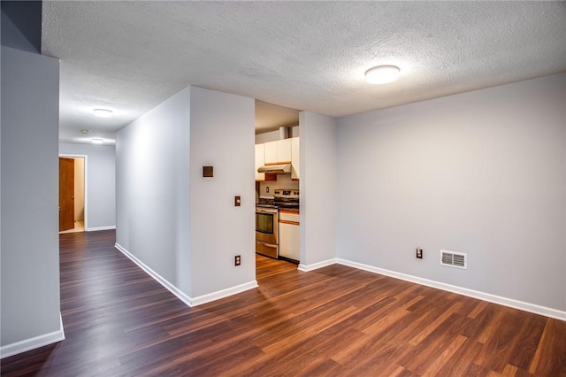 unfurnished room with dark wood finished floors, visible vents, and a textured ceiling