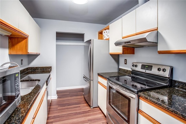 kitchen featuring under cabinet range hood, stainless steel appliances, white cabinets, and wood finished floors