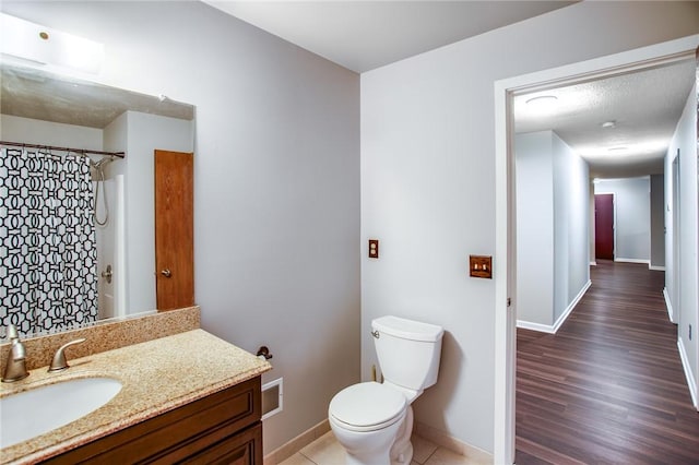 full bath featuring a shower with curtain, toilet, baseboards, vanity, and wood finished floors