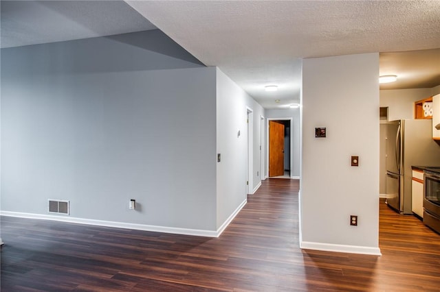 interior space with baseboards, visible vents, and dark wood-style floors