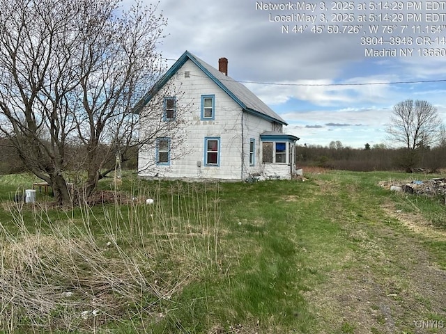 rear view of house featuring a chimney