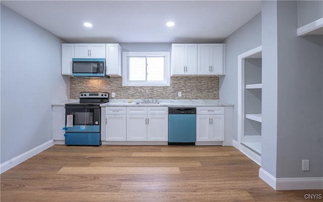kitchen featuring stainless steel microwave, a sink, electric range, dishwashing machine, and white cabinets