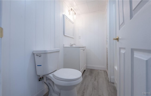 bathroom featuring toilet, wood finished floors, and vanity