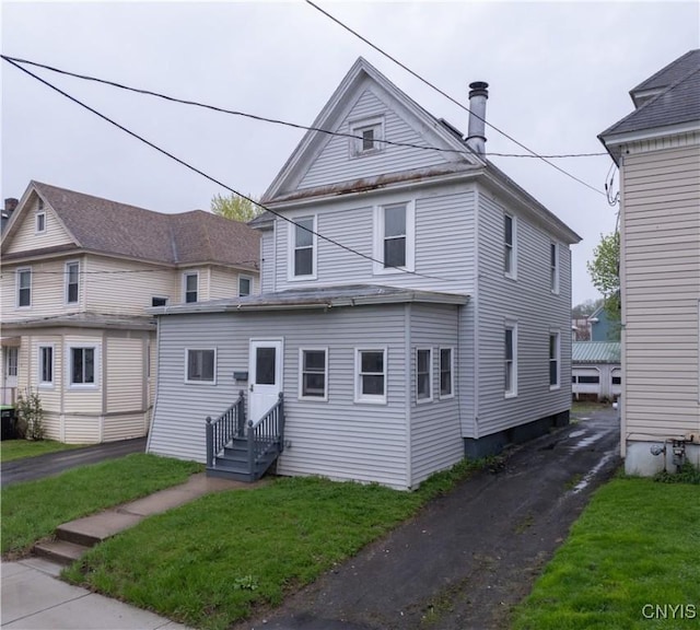 view of front of home with a chimney and a front yard
