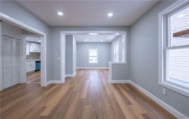 hall featuring recessed lighting, baseboards, and wood finished floors