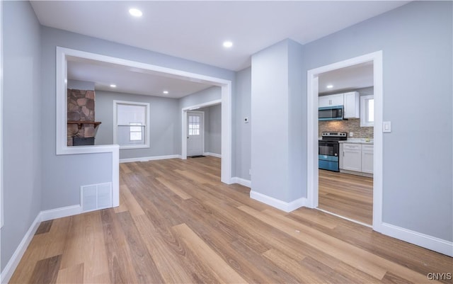 unfurnished room featuring light wood-type flooring, recessed lighting, baseboards, and visible vents