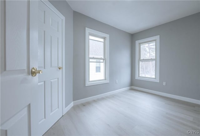 unfurnished room featuring baseboards and light wood-type flooring