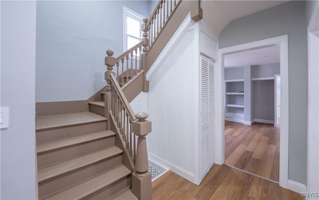 stairway with baseboards and wood finished floors
