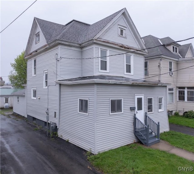view of front of home with roof with shingles and entry steps