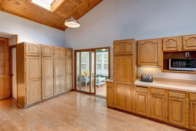 49080 State Highway 30, Roxbury, NY 12474 - kitchen featuring stainless steel microwave, a skylight, high vaulted ceiling, light countertops, and light wood-type flooring