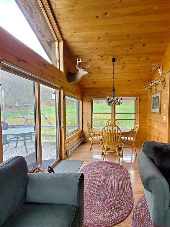 sunroom / solarium with a chandelier and baseboard heating