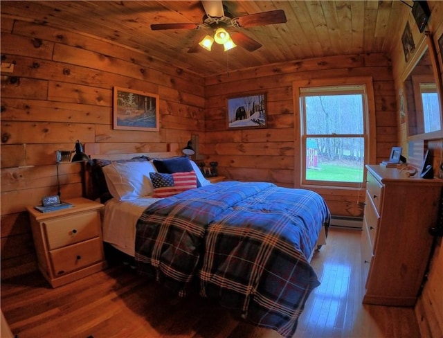 bedroom featuring multiple windows, wood ceiling, a baseboard radiator, and wood-type flooring